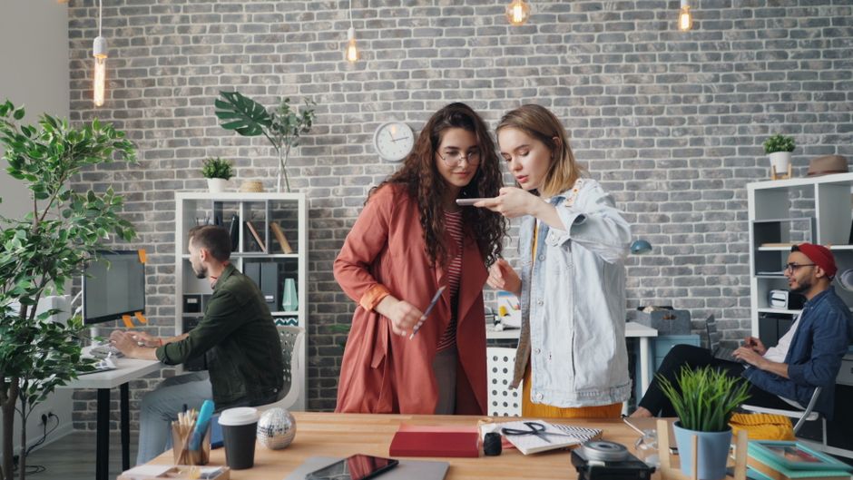 Jóvenes profesionales colaborando en un espacio de trabajo moderno, enfocados en trabajo en equipo