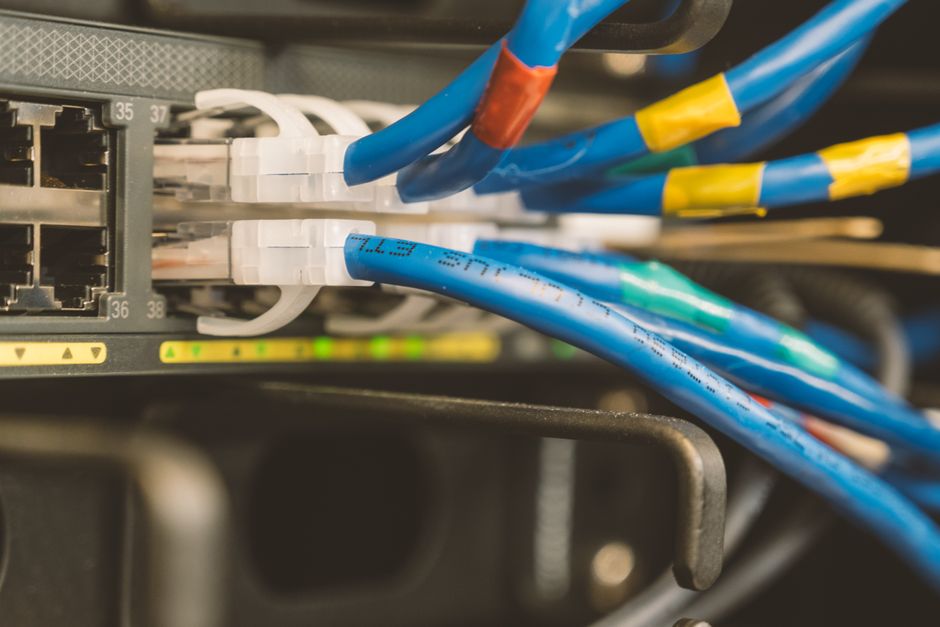 Switch de red y cable ethernet azul conectado para mantenimiento