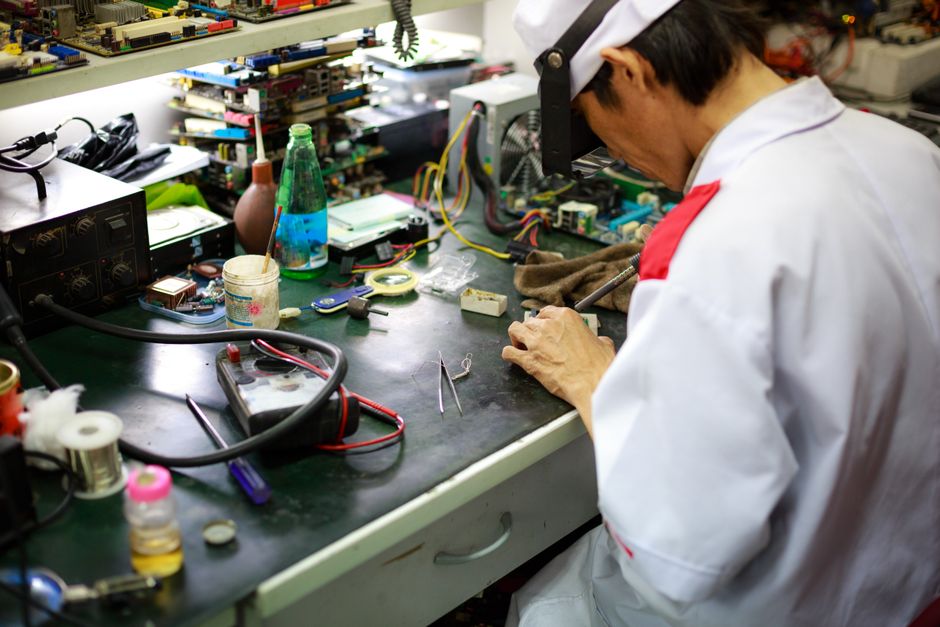 Técnico reparando componentes electrónicos en un banco de trabajo